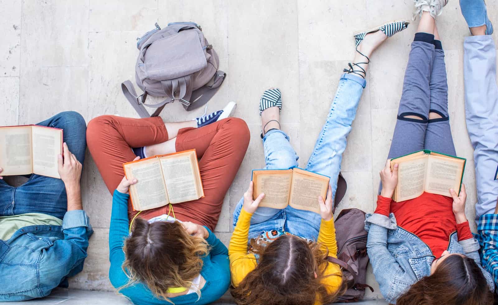 50 Outstanding Books for Your 2021 YA Summer Reading List 2 teens reading books from the 2021 ya summer reading list