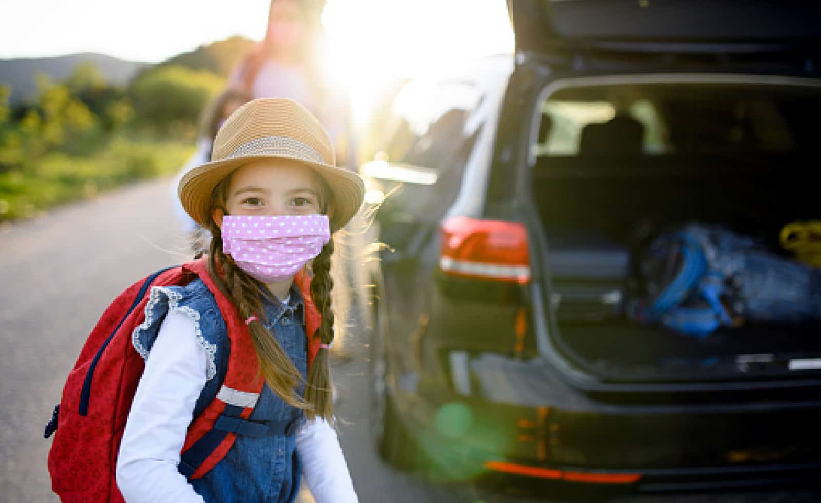 How To Vacation Safely During the Pandemic 1 Front view of small girl with family on trip outdoors in nature, wearing face masks
